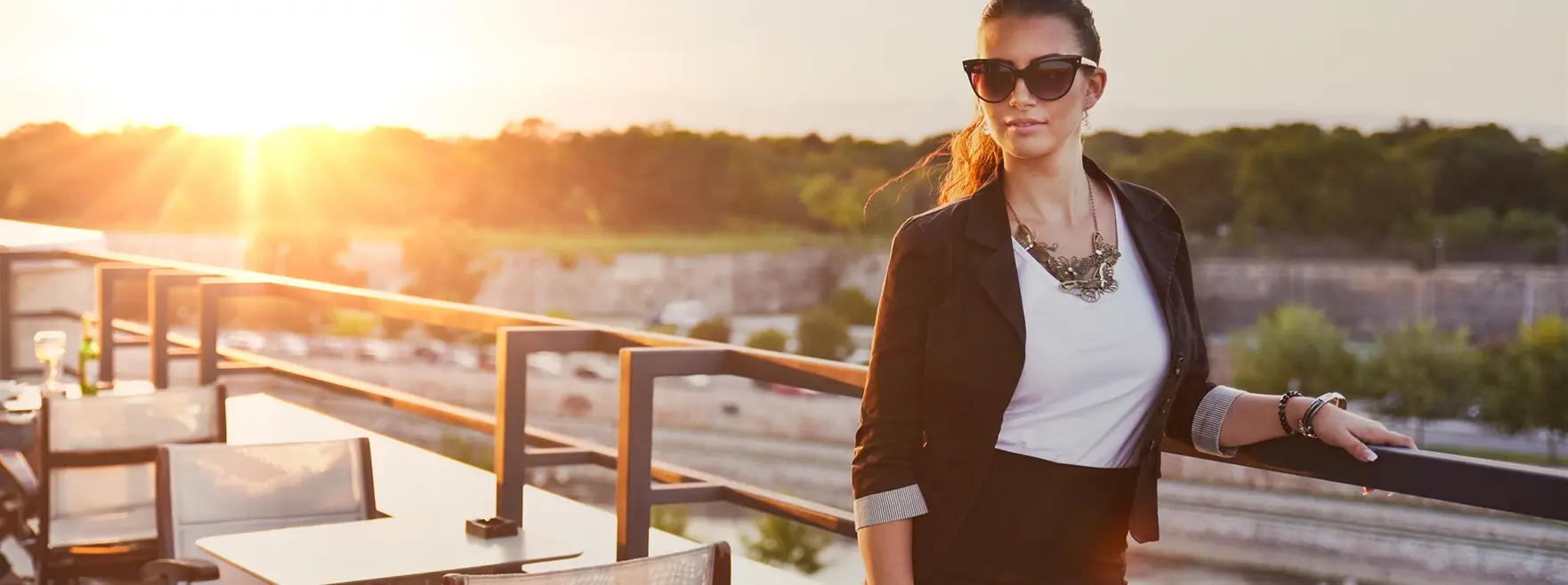 Girl with shades standing in front of a sunset view